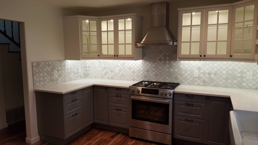 Kitchen with two-tone cabinets and arabesque tile backsplash
