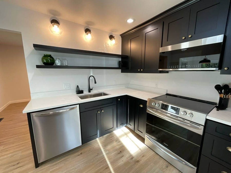 Kitchen with dark shaker cabinets and black open shelving